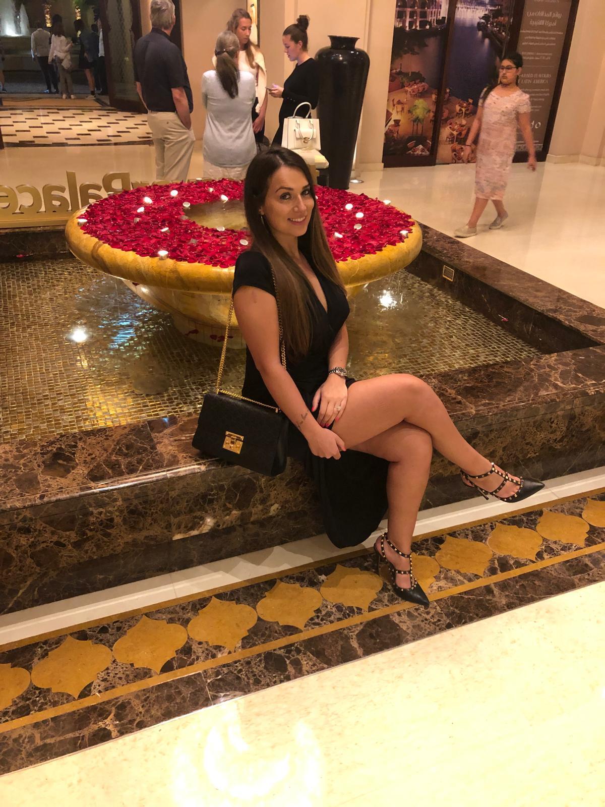 rachel buscall in black dress sat on water fountain in dubai